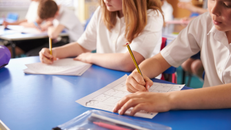 children writing on paper at school