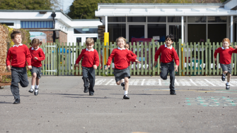 children running on playgroup, red uniforms