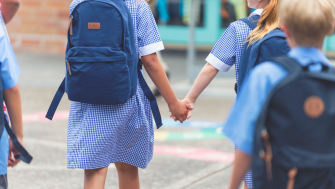 pupils holding hand with backpacks