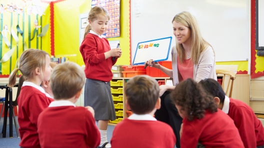 teacher with early years children in red uniform