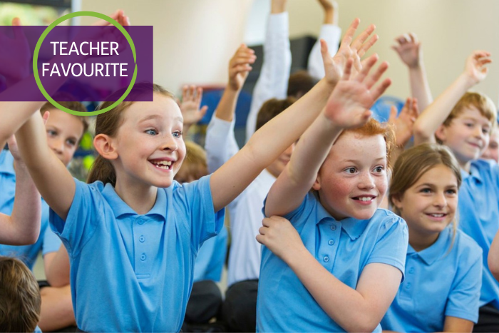 A group of children sit with their hands in the air. They are smiling and looking ahead. A graphic in the top left reads: Teacher Favourite. 
